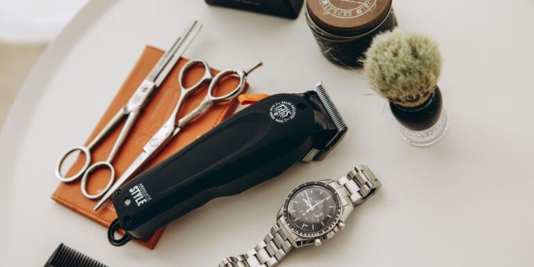 silver link bracelet round analog watch beside black leather pouch and silver and gold link bracelet