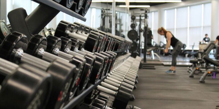 woman standing surrounded by exercise equipment