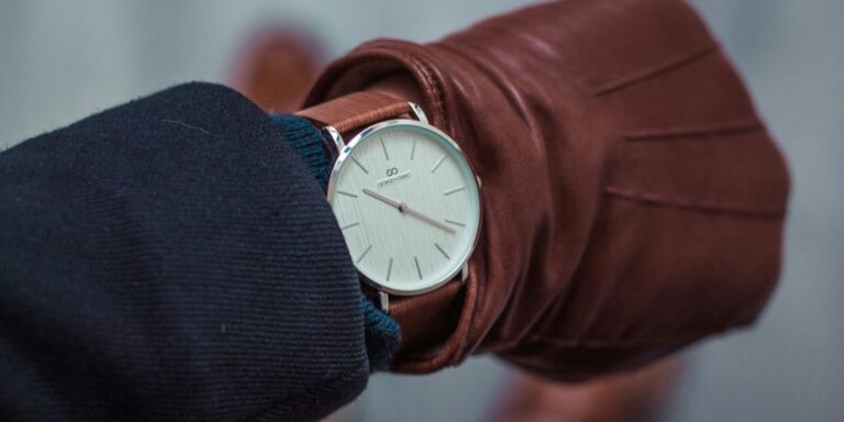 person looking at round white analog watch at 10:22