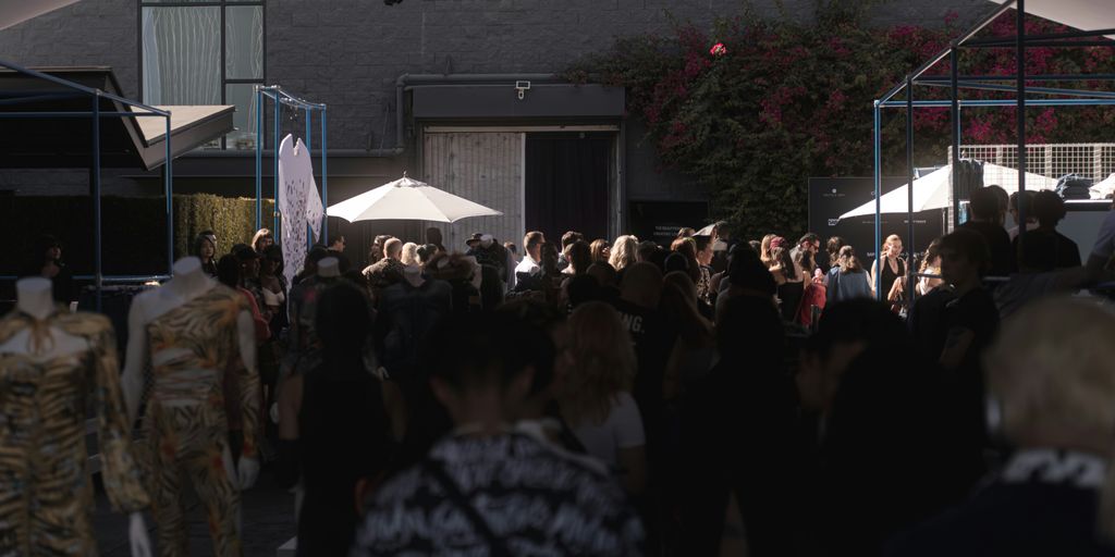 a crowd of people walking down a street next to tall buildings