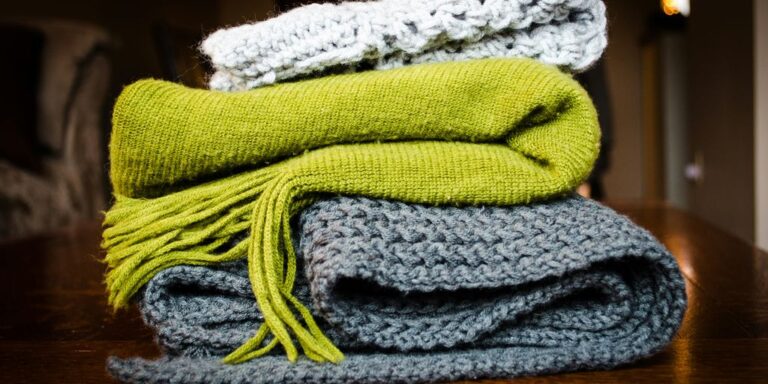 three gray, green, and white scarf on top of table